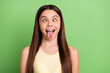 Portrait of excited carefree person squint eyes tongue out have fun isolated on green color background