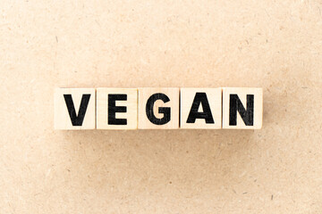 Sticker - Alphabet letter block in word vegan on wood background