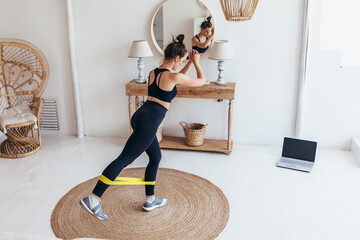 Woman working out at home with elastic band