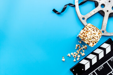 Layout of film reel with popcorn and clapperboard. Cinema concept