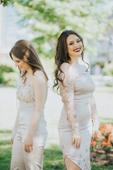 Poster - Vertical shot of two beautiful young Caucasian females posing outdoors in elegant clothing