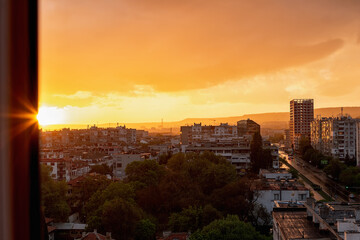 Wall Mural - amazing calm sunset in a golden hour over the small city. cityscape with the setting sun low over th