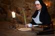 Young medieval nun writes a letter