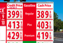 High Gas Prices On Red Sign. Cash, Credit, Debit Price For Regular, Plus And Premium Gasoline
