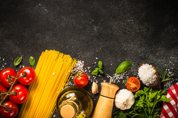 Wall Mural - Italian food background. Pasta, olive oil, spices, basil and fresh tomatoes. Top view with copy space.