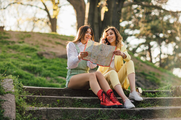 Two women sitting and holding map