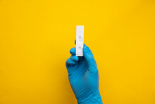 Person Wearing Blue Gloves Holding A Coronavirus Lateral Flow Test