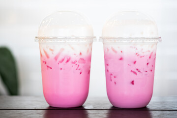 Two glass of Thai style iced pink sweet milk in coffee shop