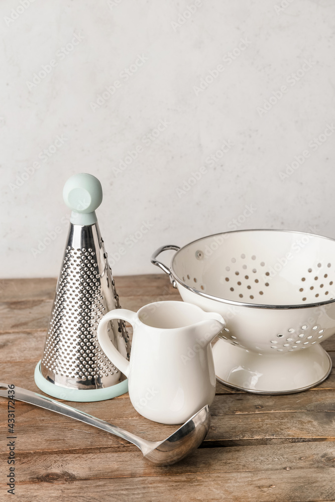 Set of kitchen utensils on light wooden background