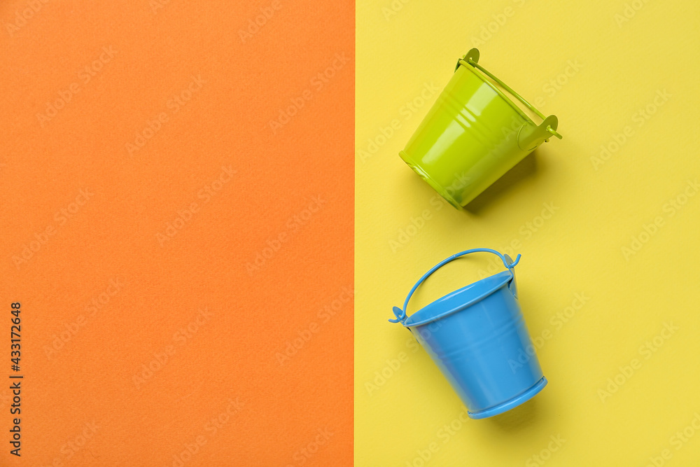 Metal buckets on color background