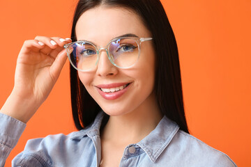 Sticker - Beautiful young woman wearing eyeglasses on color background