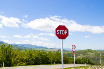 Stop sign on the road, red stop sing on the highway