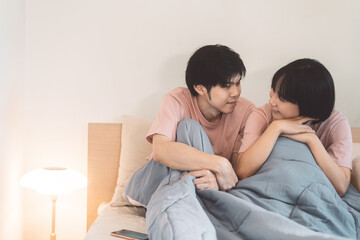 Wall Mural - Happy young adult asian lover couple living together in bedroom at home.