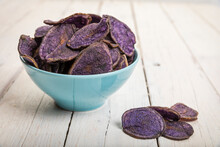 Potato Chips Made From Purple Potatoes In A Bowl On Rustic White Table