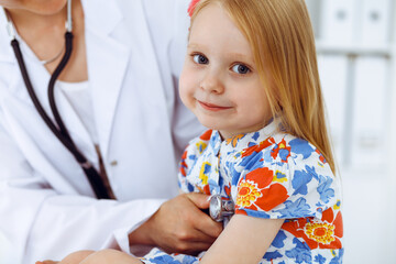 Happy smiling girl at usual medical inspection. Doctor and patient in clinic. Medicine, healthcare concepts