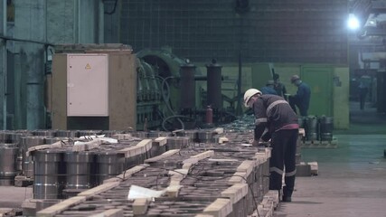 Wall Mural - Quality control of finished metal products at metallurgical plant, an inspector checks each product in bundle.