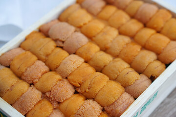 A box of uni sashimi on table served with soy sauce, Fresh sea urchin roe.