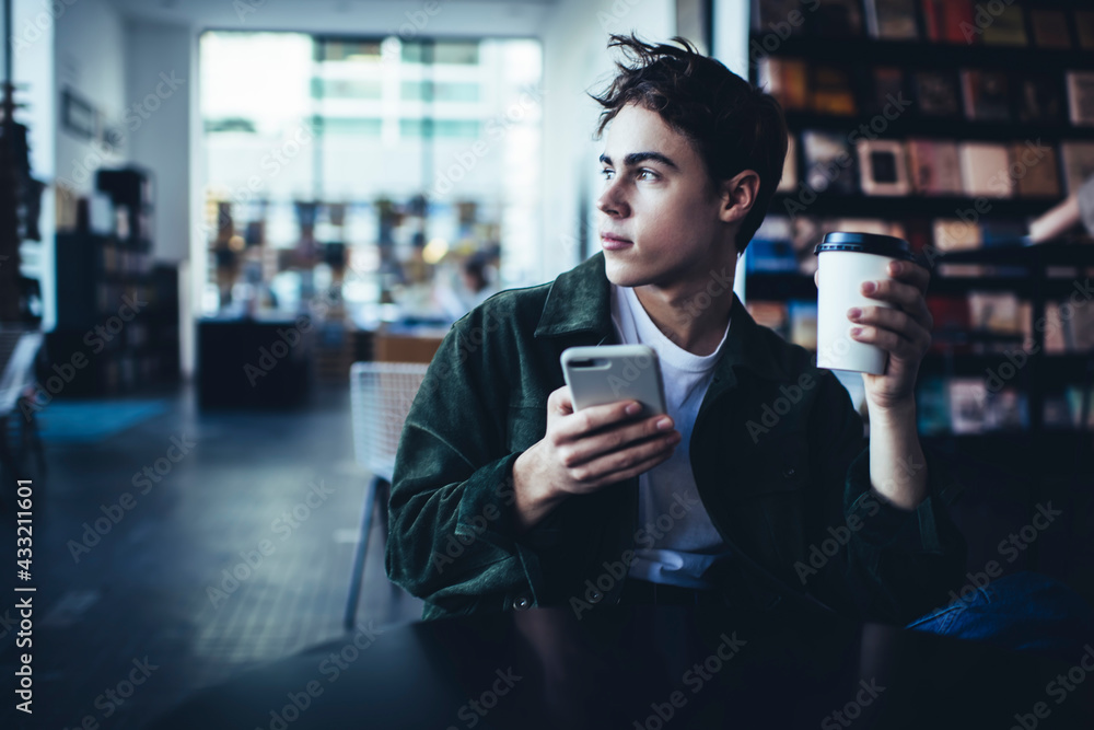 Pensive man with takeaway coffee using smartphone - obrazy, fototapety, plakaty 