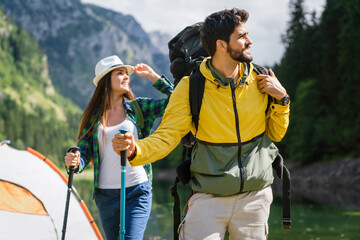 Wall Mural - Happy couple smiling outdoors on hiking trip. Young couple enjoying nature.