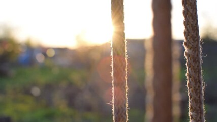 rope from a swing against the backdrop of the setting sun