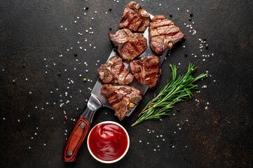 Wall Mural - several mini Grilled beef T-bone steaks on the knife on stone background