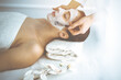 © rogerphoto - Beautiful brunette woman enjoying applying cosmetic mask with closed eyes. Relaxing treatment in medicine and spa concepts