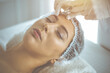 © rogerphoto - Beautician doing beauty procedure with syringe to face of young brunette woman in sunny clinic. Cosmetic medicine and surgery, beauty injections