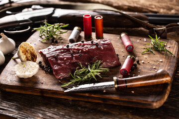 nutrient rich raw deer venison prepared for a cooking process on a rustic wooden desk with roasted g