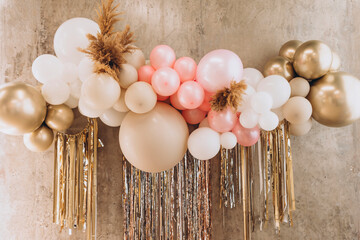 balloons with helium in pastel colors pink, white and beige as a decoration for a birthday or annive