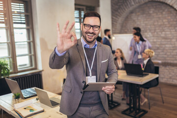 Wall Mural - Portrait of confident young businessman while colleague in background