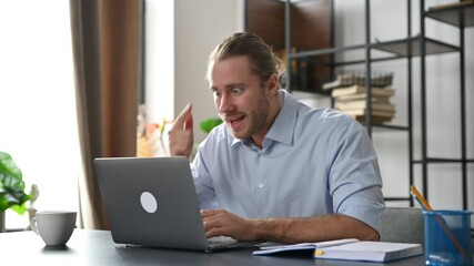 Annoyed angry american businessman, manager, has an unpleasant conversation via video conference uses laptop, sitting at workplace, disagreement with employees, irritated face expression, indignation