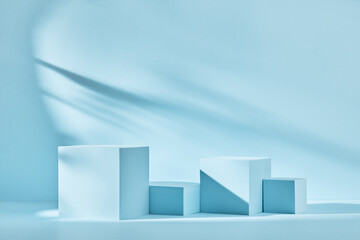 Wall Mural - Blue background for product presentation with shadows and light. Empty podiums. Mockup.