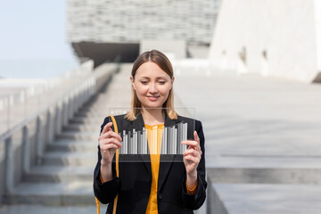 Smiling mid adult businesswoman using futuristic digital tablet outdoors