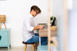 © Giorgio Fochesato/Westend61 - Young man writing while sitting at table in living room