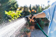 © Manu Padilla Photo/Westend61 - Woman watering with garden hose at front yard