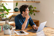 © steve brookland/Westend61 - Male freelance worker contemplating while using laptop at table