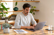 © steve brookland/Westend61 - Concentrated male freelancer sitting at table working from home on laptop