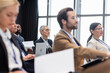 © LIGHTFIELD STUDIOS - Mature businesswoman looking away near multiethnic colleagues during seminar
