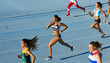 © Trevor Adeline/Caia Image - Female track and field athletes running in competition on blue track