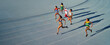 © Trevor Adeline/Caia Image - Female track and field athletes running in race on blue track