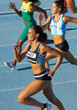 © Trevor Adeline/Caia Image - Female track and field athletes running on sunny track