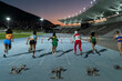 © Trevor Adeline/Caia Image - Female track and field athletes racing to hurdles on track at night