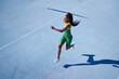 © Trevor Adeline/Caia Image - Female track and field athlete throwing javelin on sunny blue track