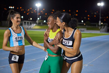 Happy Female Track And Field Athletes Celebrating And Hugging On Track