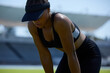 © Trevor Adeline/Caia Image - Tired female track and field athlete in visor resting