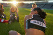 © Trevor Adeline/Caia Image - Female track and field athletes stretching before competition