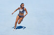 © Trevor Adeline/Caia Image - Female track and field athlete on sunny blue track