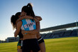© Trevor Adeline/Caia Image - Happy female track and field athletes hugging in stadium infield