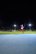 © Trevor Adeline/Caia Image - Female track and field athlete throwing javelin in stadium at night