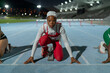 © Trevor Adeline/Caia Image - Portrait determined female runner in hijab at track starting line